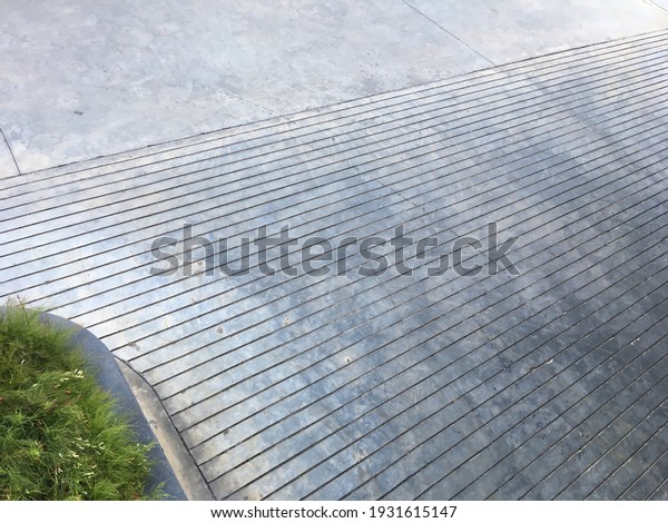 top view of concrete ramp with groove line and\
small garden beside