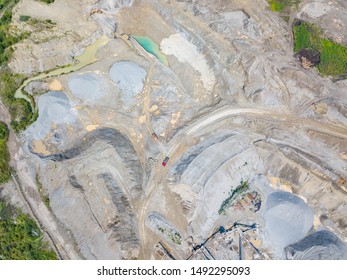 The top view of the construction site at the initial stage of construction and preparation of the ground with an excavators loading of soil for transportation