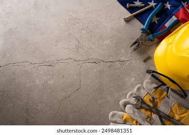 Top view of construction tools, hard hat, gloves, and American flag on a concrete surface, symbolizing Labor Day in the USA - Powered by Shutterstock