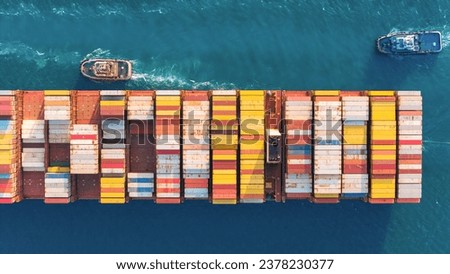 Top view Container ship full capacity approaching the port by A tugboat is pulling a cargo ship docked International Container ship loading, unloading at sea port, Freight Transportation, Shipping