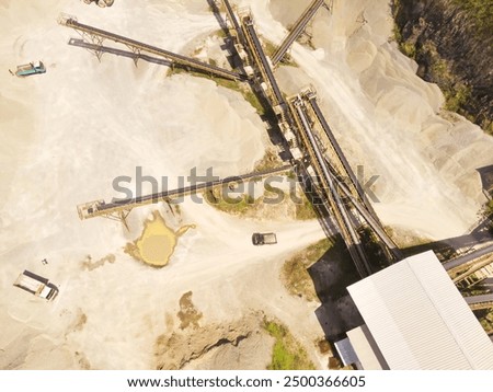 Top view of conveyor machine in the middle of the sand pit. Mining Industry. Panoramic Landscape. Mining material transportation. Sand and stone mining. Drone Photography. Aerial Photography