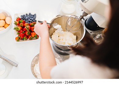 Top View. A Cook Adds A Spoonful Of Flour To Prepare Dough In A Mixer Bowl. Cooking Courses. Bread And Dessert Recipes. Family Business. Online Lessons For Cooks.