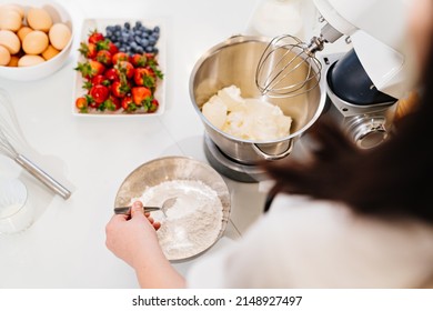 Top View. A Cook Adds A Spoonful Of Flour To Prepare Dough In A Mixer Bowl. Cooking Courses. Bread And Dessert Recipes. Family Business. Online Lessons For Cooks.