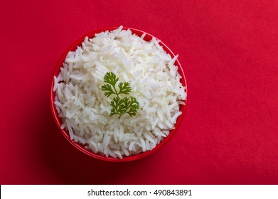 Top View Of Cooked Basmati Rice In Bowl Over Red Background
