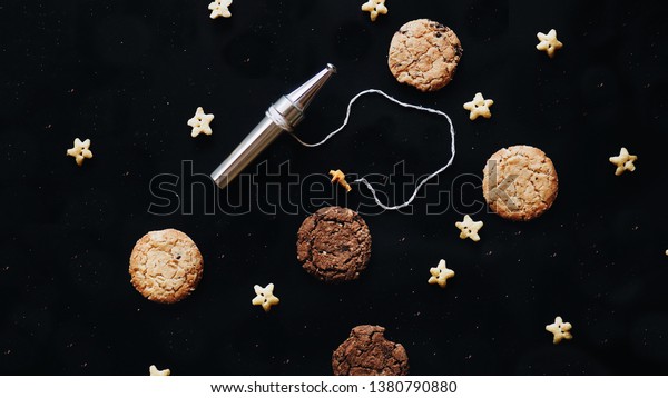 Top view cookies with miniature\
people astronaut and painting group working in galaxy.\
