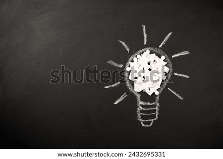 Top view with copy space of light bulb made from puzzles on blackboard background, inspiration and creative idea concept. Flat lay composition.