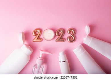 Top view of the cosmetics containers on pink background.Rose gold numbers 2023 above.Good for new year offer and text overlay. - Shutterstock ID 2236747551