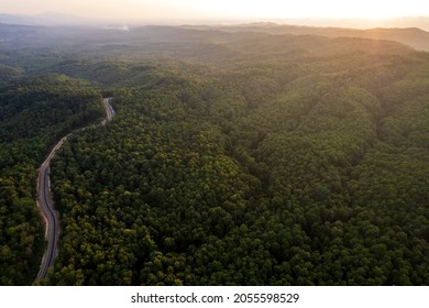 Top View Of Countryside Road Passing Through The Green Forrest And Mountain