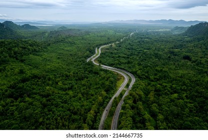 Top View Of Countryside Road Passing Through The Green Forrest And Mountain