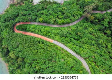 Top View Of Countryside Road Passing Through The Green Forrest And Mountain