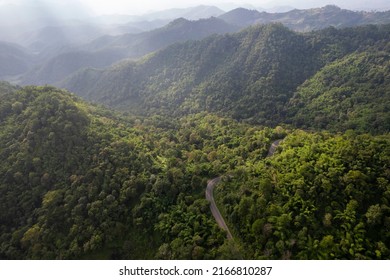 Top View Of Countryside Road Passing Through The Green Forrest And Mountain