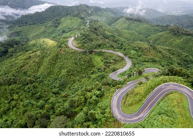 Top View Of Countryside Road Passing Through The Green Forrest And Mountain