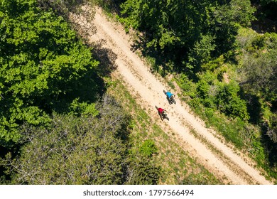 Top View Of A Couple Of Cyclists Riding Their Mountain Bikes Along A Dirt Road In The Countryside, Concept Of Sport With Friends And Healthy Lifestyle In Nature