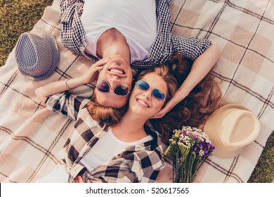 top view of a couple in love lying on a picnic plaid