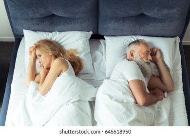 Top View Of Couple Lying In Bed Back To Back At Home