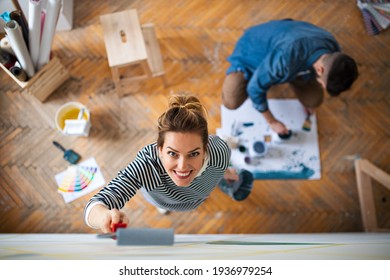 Top View Of Couple Painting Wall Indoors At Home, Relocation And Diy Concept.