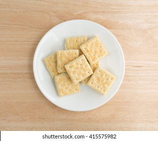 Top View Of Cream Cheese And Chives Crackers On A White Plate Atop A Wood Table Top.