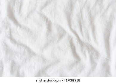 Top View Of Creased / Wrinkles On A White Unmade / Messy Bed Sheet After Waking Up In The Morning. Bedsheet Is Not Neatly Arranged For New Guests Or Customers To Sleep In. Abstract Texture Background