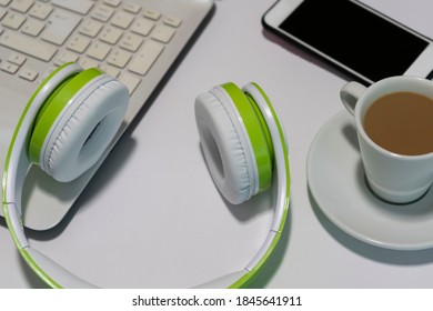Top view of creative flat lay office workspace with headphones, laptop ,smartphone and a coffee cup .Work from home,break time, freelance, digital nomad lifestyle concept.Copy space text.