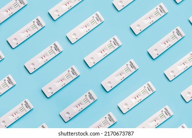 Top View Of Creative Pattern Made Of Rapid Antigen Test Kits With Different Positive And Negative For COVID-19 On Blue Background