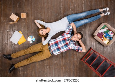 Top View Creative Photo Of Beautiful Young Couple On Vintage Brown Wooden Floor. Couple Is Ready For Home Renovation