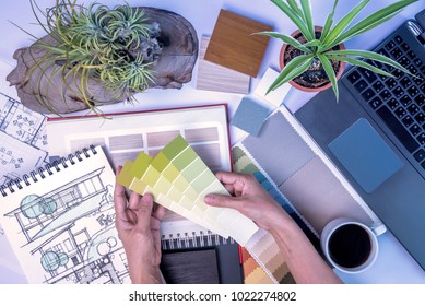 Top view of creative's (architect & interior designer) working at desk with laptop, drawing sketch / Home renovation & decoration concept