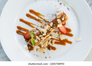 Top View Of Creme Caramel Toffee Slice With Almonds And Strawberries On White Plate. Sweet Dessert, Fancy Food Restaurant Concepts