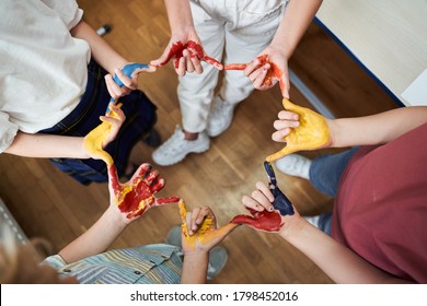 Top view cropped head of happy boys and girls standing in circle and connecting fingers coloured after drawing - Powered by Shutterstock