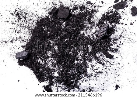 Top view of Crumbs and powders of charcoal were scattered on a white background.