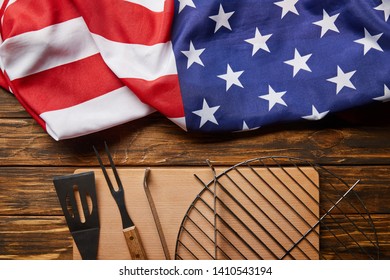 top view of crumpled american flag and bbq equipment on wooden rustic table - Powered by Shutterstock