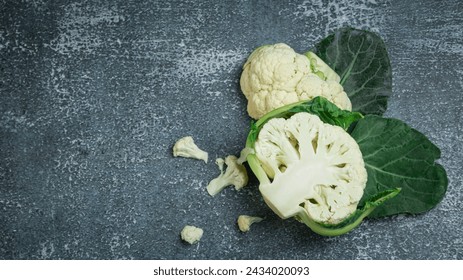 Top view. Crunchy halved fresh white cauliflower, rolled into a culinary ingredient with healthy nutrition on a gray background. - Powered by Shutterstock