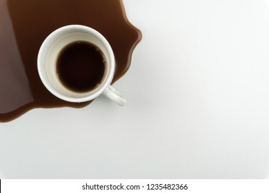 Top View Of A Cup Of Coffee And Spilled Coffee On The White Table