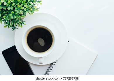 Top View Of Cup Of Coffee,notebook,smart Phone On White Table