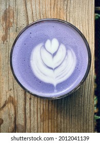Top View of a Cup of Taro Latte Art on a Wooden Table