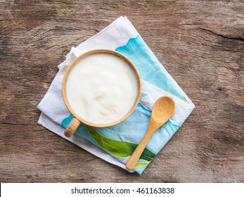 Top View Cup Of Yogurt And Spoon On Rustic Wooden Background