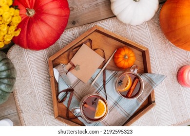 Top view cups with hot spiced tea with star anise, cinnamon stick, slice of orange on the wooden tray with decorative pumpkin, flowers and blank postcard. Cozy autumn. Tea time ideas. Selective - Powered by Shutterstock