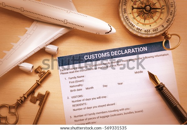 Top view of a customs declaration form with a
white model air plane, a fountain pen on a table. Customs
declaration form is a form declaring the nature and value of goods,
etc. for customs purposes.