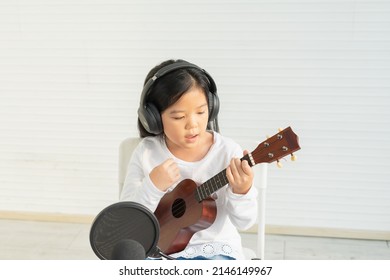 Top View Of Cute Little Children Listen Music, Singing, Show Playing Guitar, Look At Guitar. Asian Children Study And Learn Musical And Singing In Education Classroom At Small School