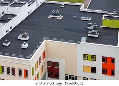 Top view dark flat roof with air conditioners and hydro insulation membranes modern apartment building residential area. - Shutterstock ID 1956505831