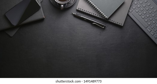 Top View Of Dark Stylish Workplace With Smartphone And Office Supplies On Black Leather Table Background 