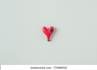 Top View Of Deflated Heart Shaped Balloon With Insulating Tape Cross Isolated On White