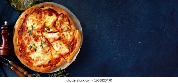 Top view of delicious and crispy vegetarian pizza Margherita on dark blue background