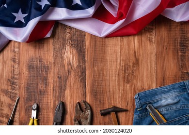 Top view design concept of Labor Day with working tools and jeans on wooden table background. - Shutterstock ID 2030124020