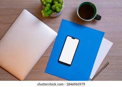 top view of a desk with a computer, cell phone, cup of coffee and documents of an office worker