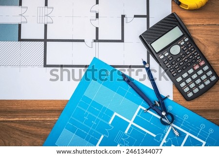 Top view desk of Engineer tools meticulously designs structures at desk, referring to blueprints for precision. Focuses on innovation, problem-solving, and attention to detail in engineering projects