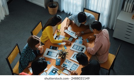 Top view of developer team designing Ux Ui design for phone interface or planning for making digital development. Startup project send develop plan to manager while sitting at boardroom. Convocation. - Powered by Shutterstock