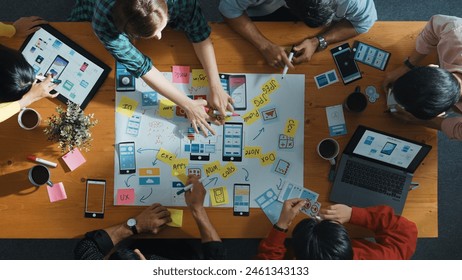 Top view of developer team sharing idea of Ux Ui design by using mind map. Top down view of group of business people working together to brainstorm or plan mobile phone interface app. Convocation. - Powered by Shutterstock