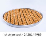 Top view of diamond cut pistachio baklava on a tray isolated on white background.