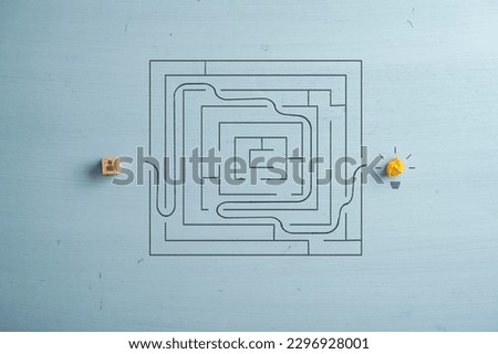 Top view of a dice with person icon trying to finda a path trough a maze or labyrinth to get to a light bulb on the other side. Conceptual image of vision, idea, strategy and determination. 