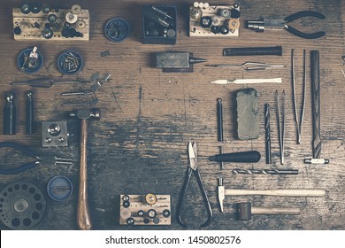 Top view of different goldsmiths tools on the jewelry workplace. Desktop for craft jewelry making with professional tools. Aerial view of tools over rustic wooden background. Postcard design - Powered by Shutterstock